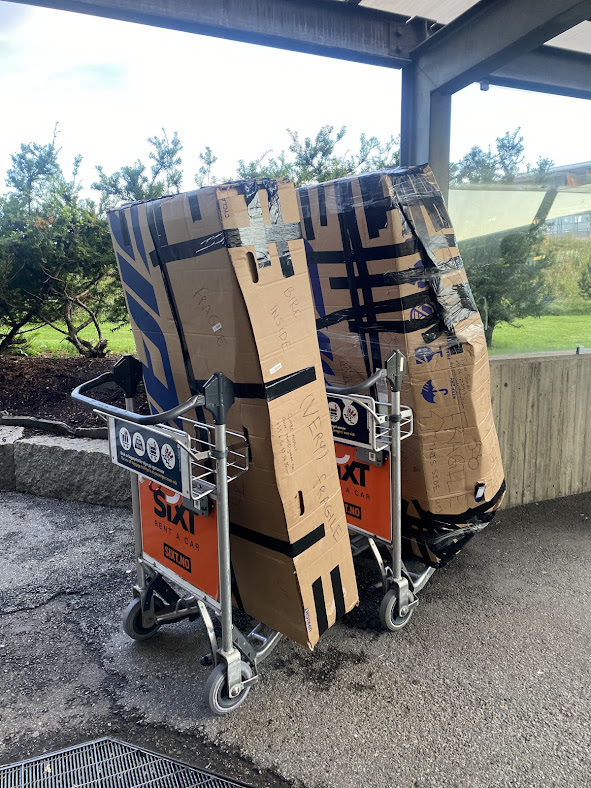 Two cardboard boxes on airport trolleys 